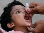 A health worker administers a polio vaccine to a child at a railway station in Karachi, Pakistan.