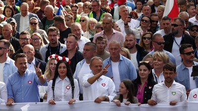 Donald Tusk, the leader of the largest opposition grouping Civic Coalition (KO) and Rafal Trzaskowski, mayor of Warsaw march in front of the Polish national flag during the "Marsz Miliona Serc" rally, in Warsaw, Poland. (Reuters)