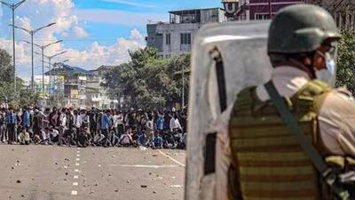 A security personnel stands guard as protesters gather against the killing of two Meitei students in Imphal last week. (PTI)