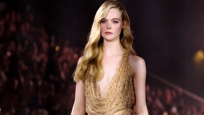 Actor Elle Fanning looks gorgeous in a beige-gold embellished sleeveless gown for the L'Oreal Paris show near the Eiffel Tower during Paris Fashion Week.&nbsp; (REUTERS)