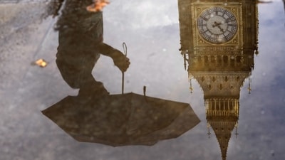 A woman with an umbrella and the Elizabeth Tower also known as Big Ben are reflected in a puddle in London. (AP) A woman with an umbrella and the Elizabeth Tower also known as Big Ben are reflected in a puddle in London. (AP)