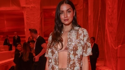 Ana de Armas made heads turn at the Louis Vuitton Spring-Summer show in an embroidered rusted bronze gold outfit featuring a half-sleeved open shirt, silk-satin bralette, and high-waisted straight-fit pants. She styled the ensemble with high heels, an LV handbag, rings, a dainty bracelet, a matching chain, earrings, open tresses, and striking glam picks. (Vianney Le Caer/Invision/AP) Ana de Armas made heads turn at the Louis Vuitton Spring-Summer show in an embroidered rusted bronze gold outfit featuring a half-sleeved open shirt, silk-satin bralette, and high-waisted straight-fit pants. She styled the ensemble with high heels, an LV handbag, rings, a dainty bracelet, a matching chain, earrings, open tresses, and striking glam picks. (Vianney Le Caer/Invision/AP)