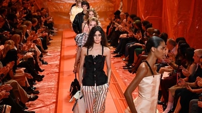 The collection was a riot of colours, ludic patterns, and subtle riffs on harlequins. Some described it as a visual feast. It featured models strutting the ramp in striped high-waisted trousers, billowing yellow silk sleeves, voluminous silhouettes, and a mix of modern and past subtleties. These elements describe the show. In this picture, models present Ghesquière's creations in front of the audience. (AFP) The collection was a riot of colours, ludic patterns, and subtle riffs on harlequins. Some described it as a visual feast. It featured models strutting the ramp in striped high-waisted trousers, billowing yellow silk sleeves, voluminous silhouettes, and a mix of modern and past subtleties. These elements describe the show. In this picture, models present Ghesquière's creations in front of the audience. (AFP)
