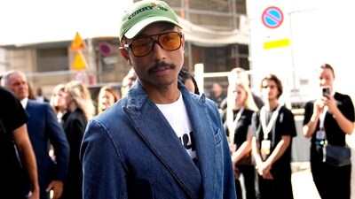 Louis Vuitton's men's creative director, Pharrell Williams, arrived at the Paris Fashion Week Spring-Summer show in a denim-on-denim look. He styled the double-breasted denim blazer and pants with a white printed tee, stacked bracelets, a Khaki green baseball cap, tinted sunglasses, diamond studs, and boots. (AP) Louis Vuitton's men's creative director, Pharrell Williams, arrived at the Paris Fashion Week Spring-Summer show in a denim-on-denim look. He styled the double-breasted denim blazer and pants with a white printed tee, stacked bracelets, a Khaki green baseball cap, tinted sunglasses, diamond studs, and boots. (AP)