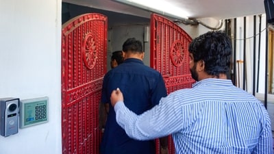 A senior police officer arrives at the office of NewsClick at Sainik Farm during raids by Delhi Police's Special Cell on its premises in New Delhi on Tuesday. (PTI)