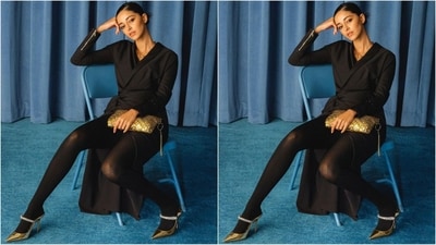 Last but not least, her black-draped dress look is all about grace and glamour. Her dress features full sleeves with a zip detail at the bottom, a draped tie-up pattern at the waist and a thigh-high side slit. She accessorised with black stockings, gold heels and a gold textured clutch. (Instagram/@priyankarkapadia)