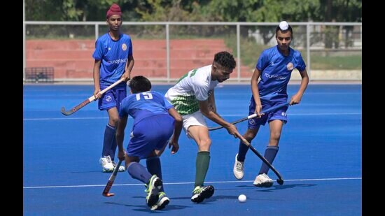 (In blue) Round Glass Chachrari (in white) Malwa Academy Hockey team players in action during the boys final match in Ludhiana on Tuesday. (Gurpreet Singh/HT)