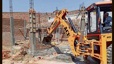 An MC team taking down illegal commercial constructions in Dhandari Kalan. (HT)