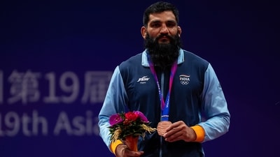 Sunil Kumar celebrates with bronze medal after the wrestling men's greco-roman 87kg final match at the 19th Asian Games in Hangzhou, China (AP)