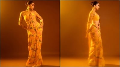 Sharvari styled the six yards with a matching blouse featuring a floral-printed sleeve cover and a fitted orange bralette top. She glammed up the attire with statement jhumkis, winged eyeliner, subtle eye shadow, on-fleek highlighter, nude lip shade, darkened brows, rouged cheeks, and a pulled-back top knot.&nbsp; (Instagram)