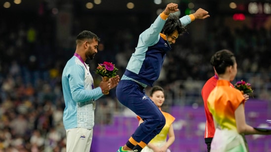 Neeraj Chopra jumps in celebration with silver medalist compatriot Kishore Kumar Jena during the presentation ceremony of men's javelin throw final at the 19th Asian Games (PTI)