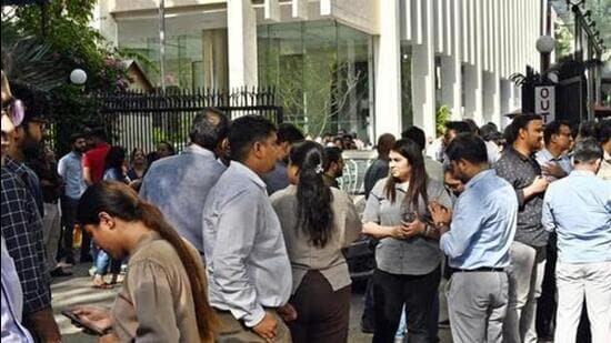 People gather outside their offices after tremors were felt in New Delhi on Tuesday. (Ajay Aggarwal/HT)