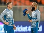 England's Moeen Ali (R) interacts with his team captain Jos Buttler during a practice session on the eve of their 2023 ICC men's cricket World Cup one-day international (ODI) match against New Zealand