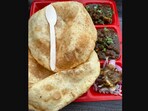 The image shows a plate of chole bhature. The image shows a plate of chole bhature.