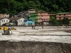 People walk along the area affected by the flood at Golitar, in Singtam, Sikkim, 