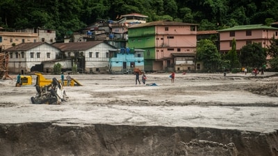People walk along the area affected by the flood at Golitar, in Singtam, Sikkim, (REUTERS)