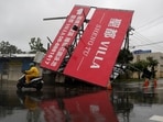 A person on a scooter drives past a fallen billboard after Typhoon Koinu passed the southern tip of Taiwan on October 5.