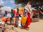 A woman walks with her children, who fled amid drought, to build a makeshift shelter at a camp for the displaced people on the outskirts of Mogadishu, Somalia.(AP)