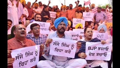Punjab cabinet minister Kuldeep Singh Dhaliwal with AAP leaders and workers stage a protest against the arrest of AAP Rajya Sabha MP Sanjay Singh by the enforcement directorate, at Bhandari Bridge in Amritsar on Friday. (Sameer Sehgal/HT)