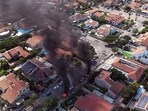 Israel-Palestine Latest: An aerial view shows vehicles on fire as rockets are launched from the Gaza Strip, in Ashkelon, southern Israel.