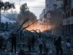 People walk atop the rubble of a tower destroyed in an Israeli air stike in Gaza City People walk atop the rubble of a tower destroyed in an Israeli air stike in Gaza City