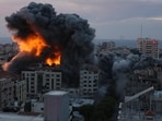 Fire and smoke rise from an explosion on a Palestine apartment tower following an Israeli air strike in Gaza City, 