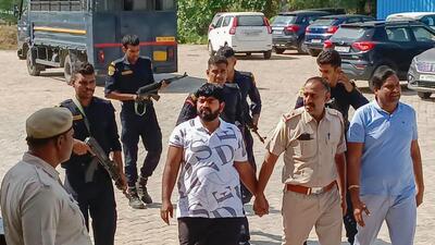 Gurugram police personnel with Monu Manesar on Saturday. (PTI) Gurugram police personnel with Monu Manesar on Saturday. (PTI)