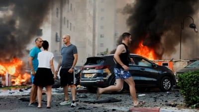 People react on the road, in the aftermath of rocket barrages that were launched from Gaza, in Ashkelon, Israel October 7, 2023. (REUTERS)