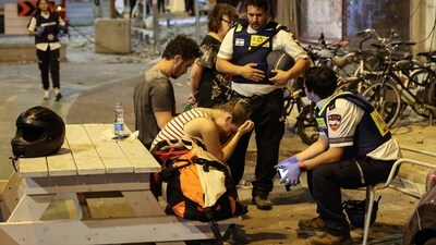 A young woman reacts as she speaks to Israeli rescuers  in Tel Aviv, after a was hit by a rocket fired by Palestinian militants from the Gaza Strip (AFP)