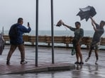 People pose for photos, as Typhoon Koinu approaches, in Hong Kong, China October 8, 2023. Hong Kong raises third-highest storm warning for Typhoon Koinu, closes transport services and schools 
