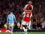 Arsenal's French defender #02 William Saliba and Arsenal's Brazilian defender #06 Gabriel Magalhaes celebrate on the pitch 