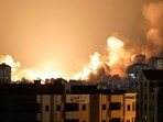 A plume of smoke rises above buildings in Gaza City during an Israeli air strike, on October 8, 2023. 