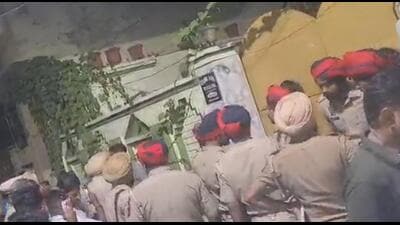 A crowd and police personnel gathered outside the house in Jalandhar where an explosion took place due to compressor blast. (HT Photo)