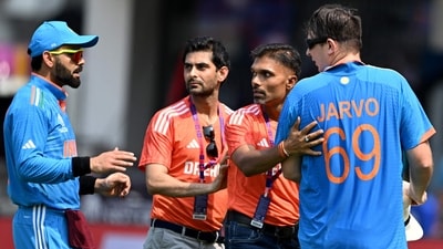 Officials stop a pitch invader as Virat Kohli watches before the start of the 2023 World Cup match between India and Australia in Chennai (AFP) Officials stop a pitch invader as Virat Kohli watches before the start of the 2023 World Cup match between India and Australia in Chennai (AFP)