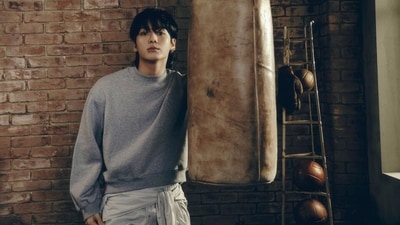 This photo shows JK striking a pose in a grey jumper featuring a baggy silhouette, a crew neckline, cinched cuffs, and full-length sleeves. He wore it with grey pants, a lip ring, ear cuffs, and a messy hairdo. (Instagram) This photo shows JK striking a pose in a grey jumper featuring a baggy silhouette, a crew neckline, cinched cuffs, and full-length sleeves. He wore it with grey pants, a lip ring, ear cuffs, and a messy hairdo. (Instagram)