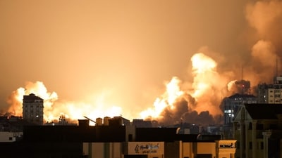 A plume of smoke rises above buildings in Gaza City during an Israeli air strike, on October 8, 2023. (AFP)