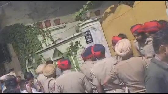 A crowd and police personnel gathered outside the house in Jalandhar where an explosion took place due to compressor blast. (HT Photo)
