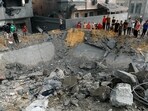 Palestinians gather around the rubble of a building destroyed in Israeli strikes, in the southern Gaza Strip October 9, 2023.