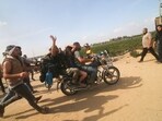 Palestinians transport a captured Israeli civilian, centre, from Kfar Azza kibbutz into the Gaza Strip on Saturday.