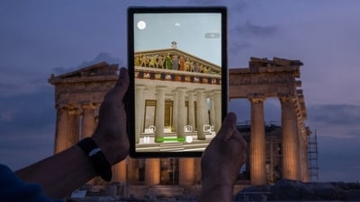 A man holds up a tablet showing a digitally overlayed virtual reconstruction of the ancient Parthenon temple, at the Acropolis Hill in Athens, Greece. (AP ) A man holds up a tablet showing a digitally overlayed virtual reconstruction of the ancient Parthenon temple, at the Acropolis Hill in Athens, Greece. (AP )
