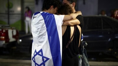 People embrace as they attend a demonstration in support of Israel, (REUTERS)