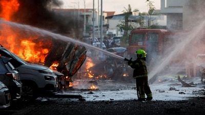 An emergency personnel works to extinguish the fire after rockets are launched from the Gaza Strip, as seen from the city of Ashkelon, Israel October 7, 2023 (REUTERS/Amir Cohen/File Photo) (REUTERS)