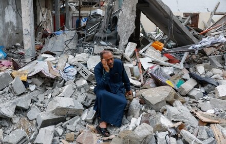 A Palestinian sits on the rubble of a building destroyed in Israeli strikes, in Rafah in the southern Gaza Strip on October 9. (Reuters)