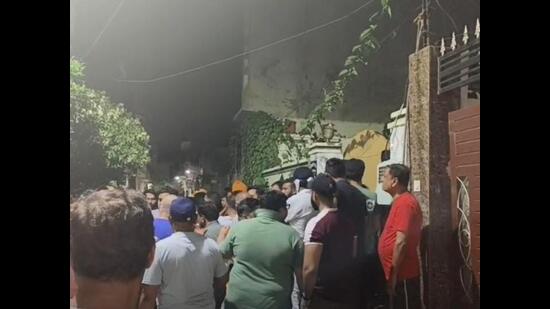 Smoke billowing from the house in Jalandhar’s Anand Nagar on Sunday night as neighbours look on. (HT Photo)