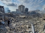 Palestinians walk through the rubble of buildings destroyed by Israeli airstrikes in Gaza City Palestinians walk through the rubble of buildings destroyed by Israeli airstrikes in Gaza City