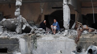 Palestinians sit among rubbles of a damaged residential building, in the aftermath of Israeli strikes, in Gaza City, October 10, 2023. (Reuters)