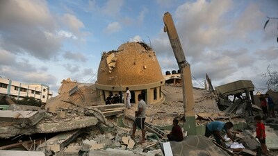 People stand outside a mosque destroyed in an Israeli air strike in Gaza Strip on October 8. (AP) People stand outside a mosque destroyed in an Israeli air strike in Gaza Strip on October 8. (AP)