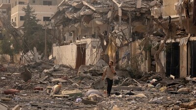 Israel-Palestine War: A Palestinian man talks on his mobile phone as he walks through a ravaged street. (AFP) Israel-Palestine War: A Palestinian man talks on his mobile phone as he walks through a ravaged street. (AFP)