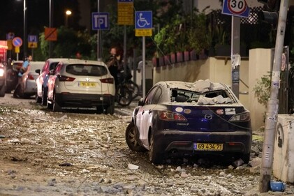 People assess the damage in a street in Tel Aviv, after it was hit by a rocket fired by Hamas militants from the Gaza Strip on October 7, 2023. (AFP) People assess the damage in a street in Tel Aviv, after it was hit by a rocket fired by Hamas militants from the Gaza Strip on October 7, 2023. (AFP)