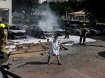 Israeli firefighters work to put out vehicles on fire after a rocket, launched from the Gaza Strip, landed in Ashkelon, southern Israel on Wednesday.